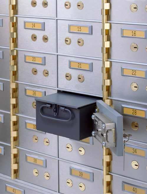 Wall of private safe deposit boxes with an open drawer